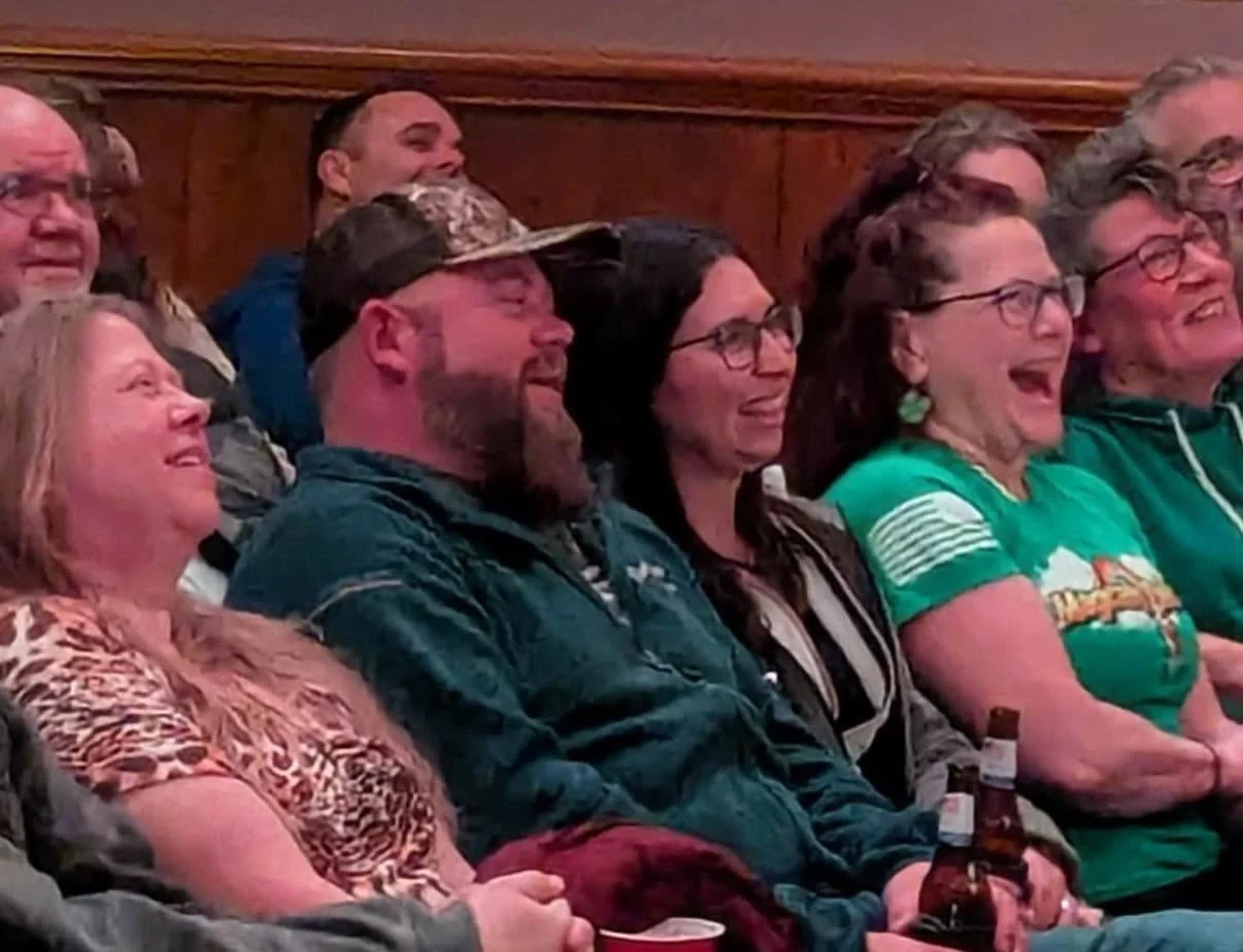 Audience members laughing together at a Comedy Series show